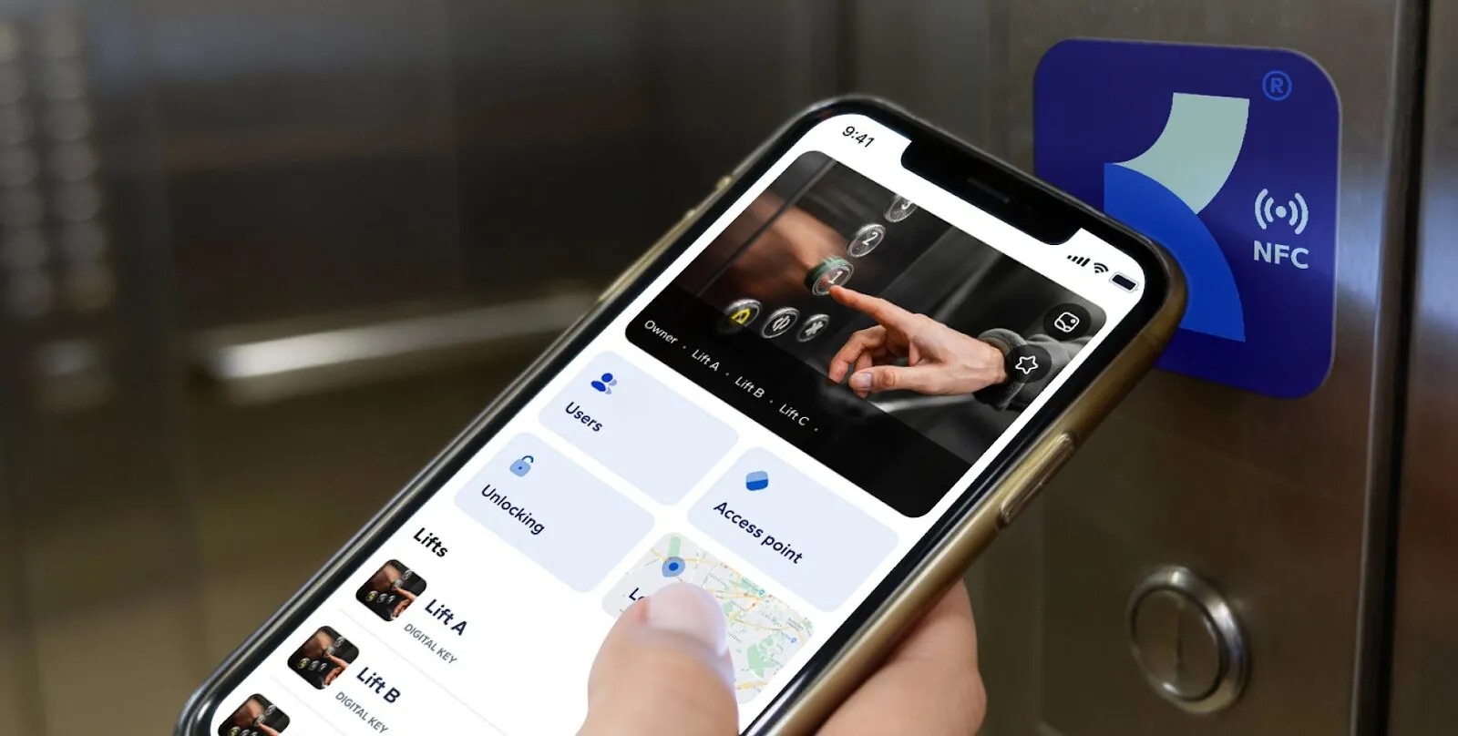 Smartphone mit der Smart MasterKey App an einem NFC-Aufkleber im Aufzug